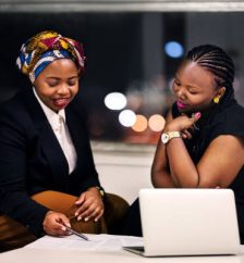 Shot of two business women discussing over some contract document in office